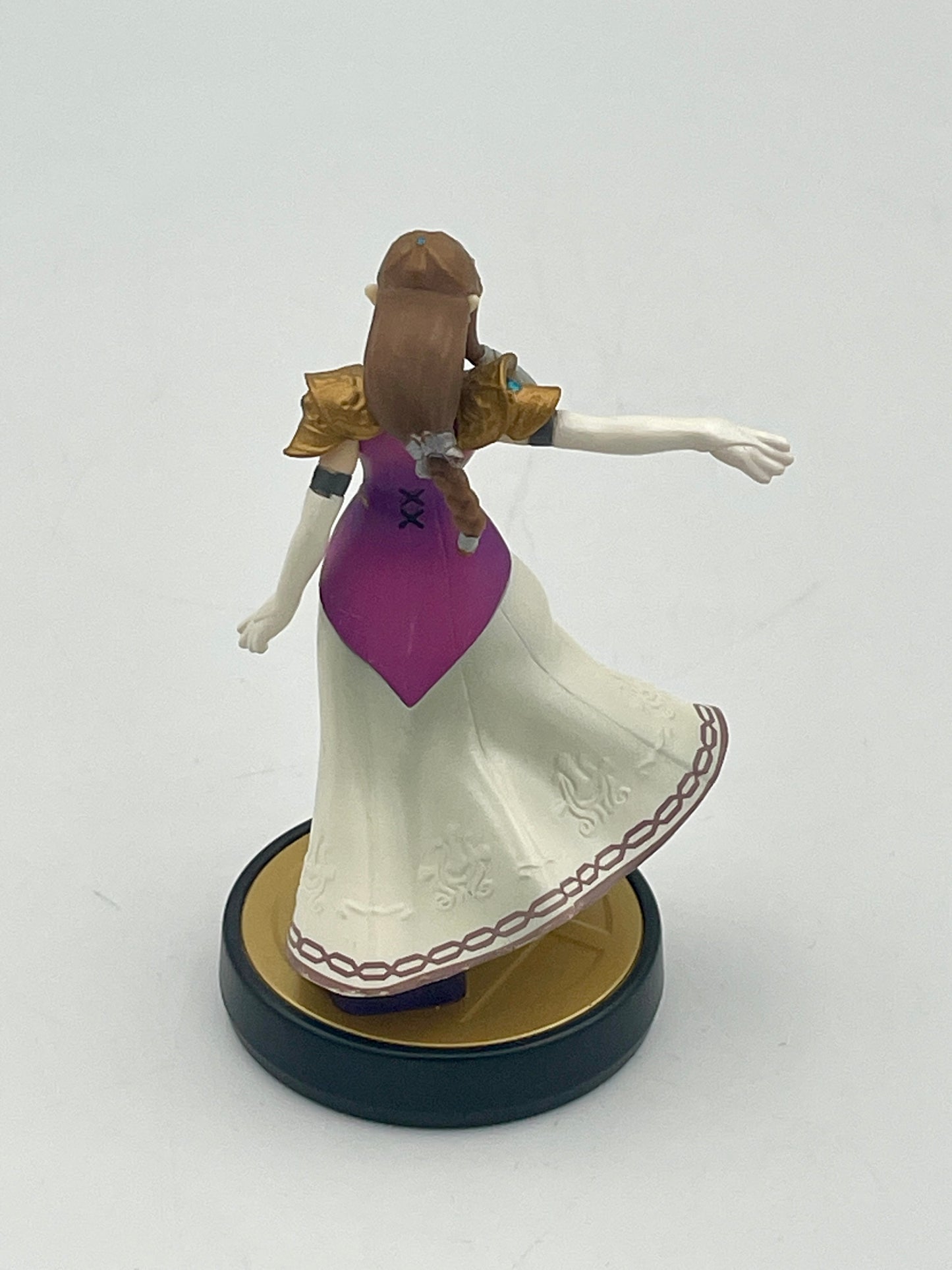 Figurine of a character in a white dress with a purple top on a white background