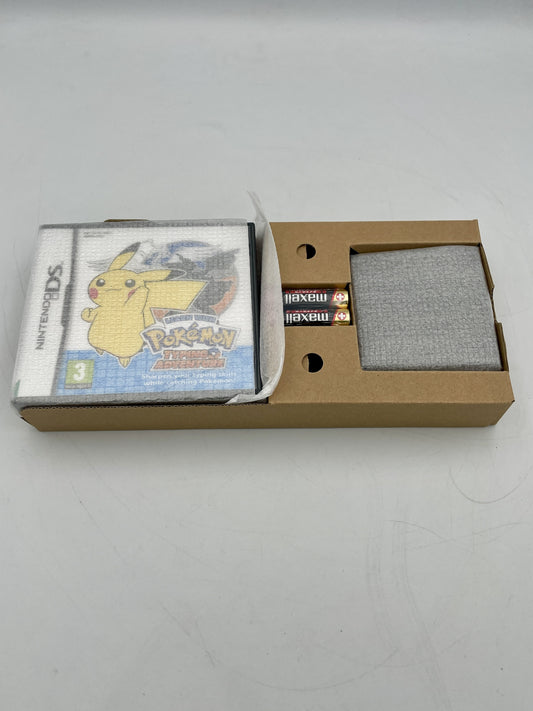 Nintendo DS game case with Pikachu on the cover, placed inside a cardboard box.