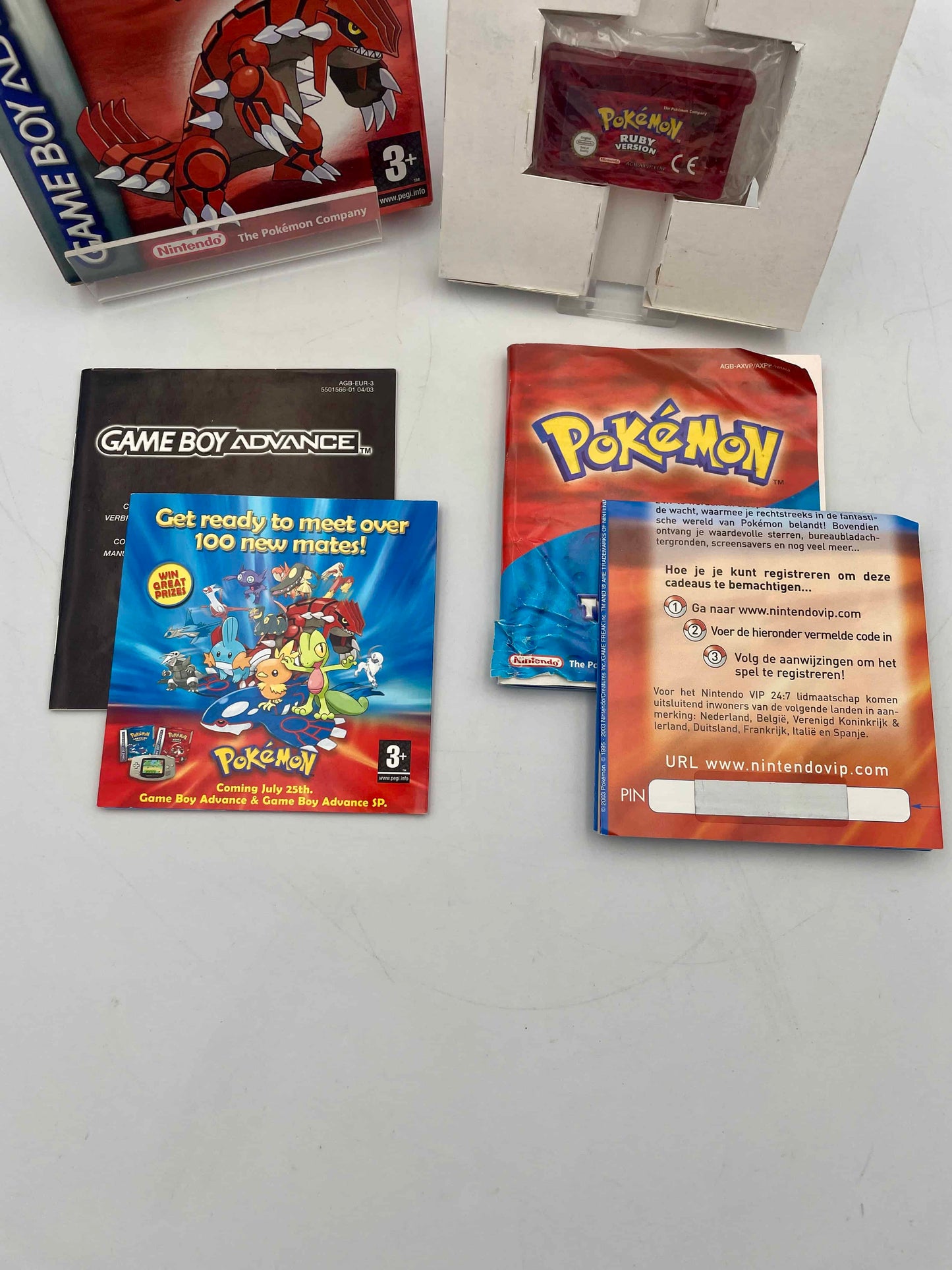 Pokémon trading cards and Game Boy Advance manual on a white surface