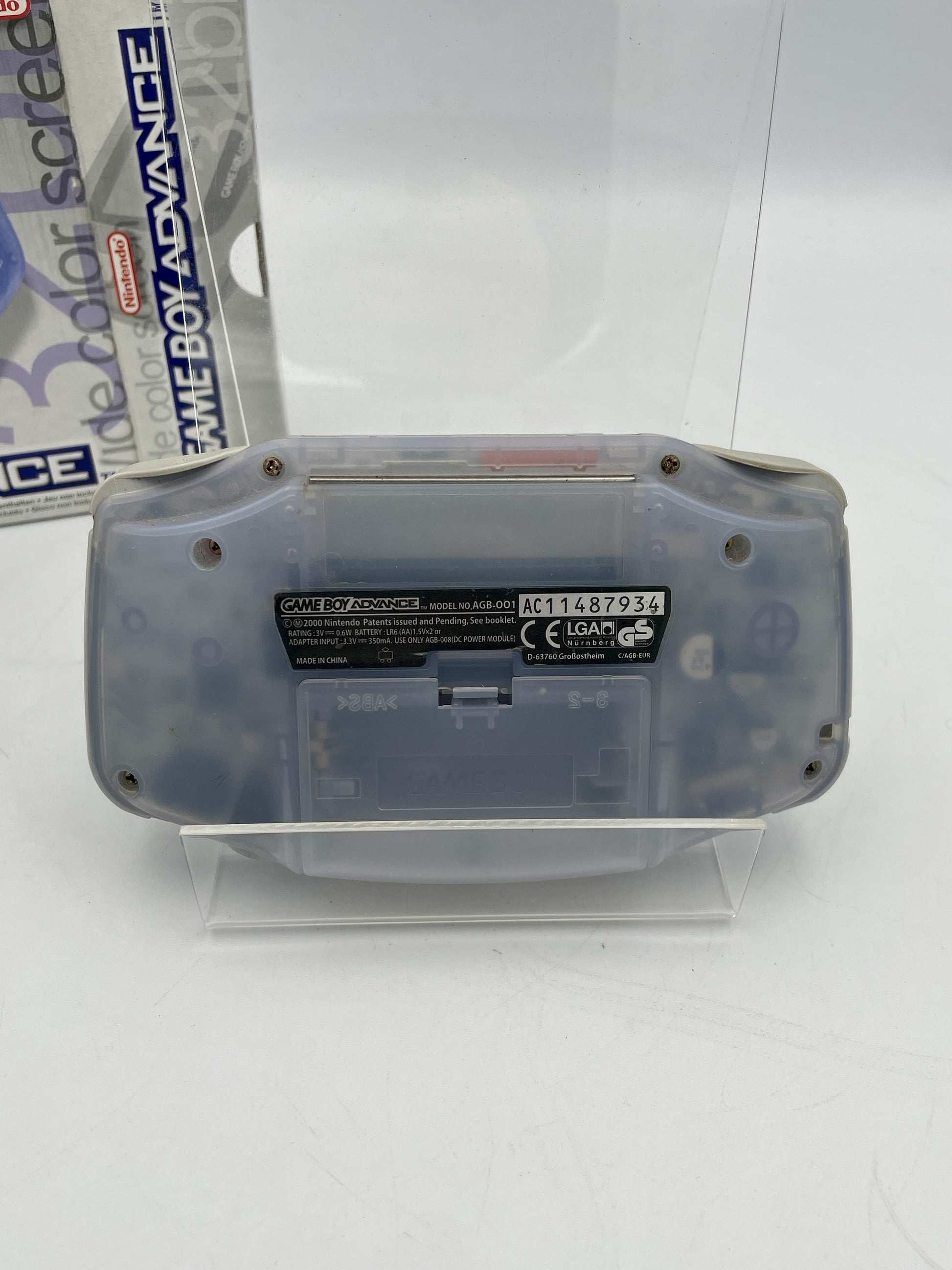 Clear Game Boy Advance shell on a stand with a white background