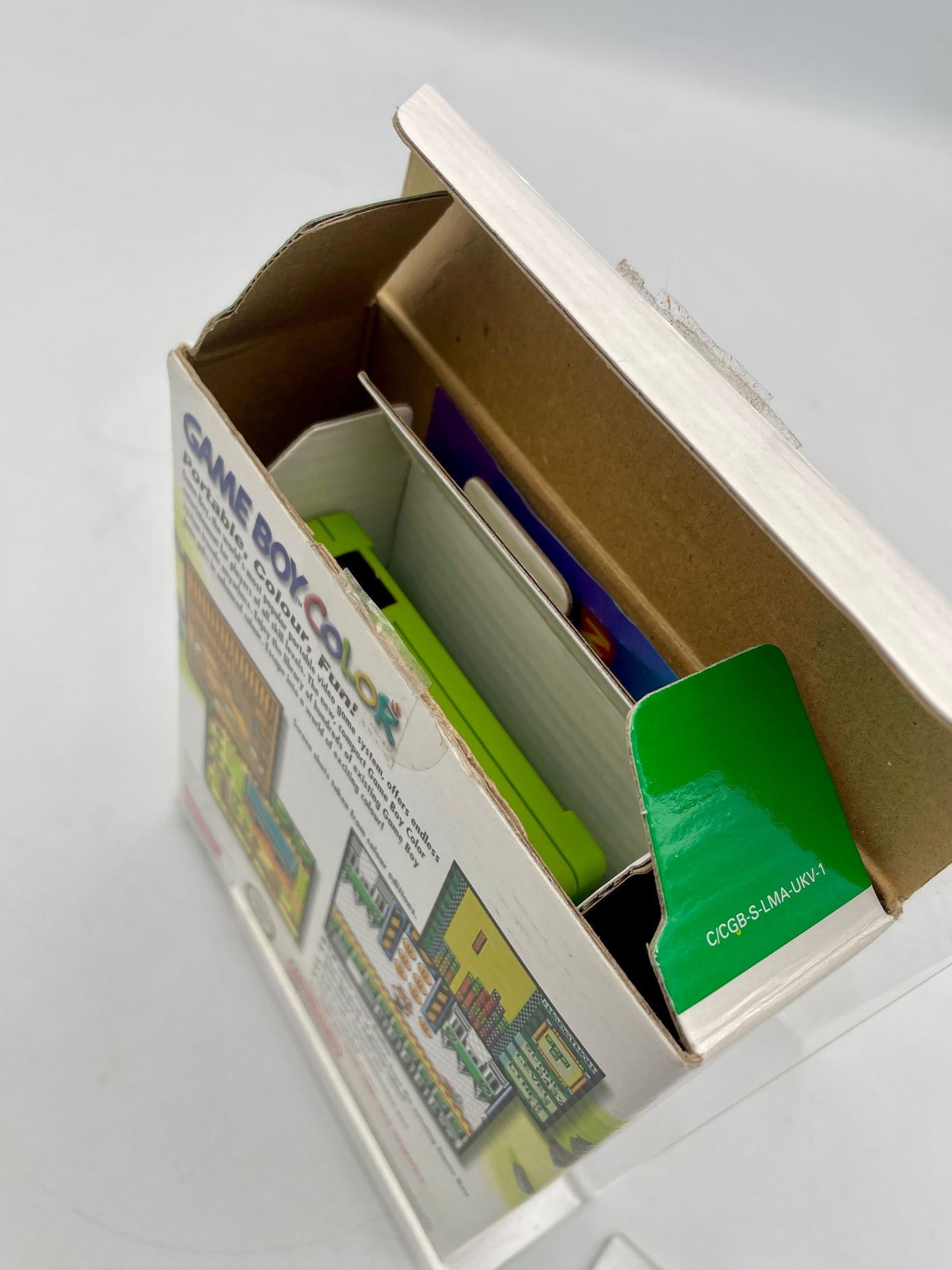 Open cardboard box with colorful game boxes inside on a light gray background