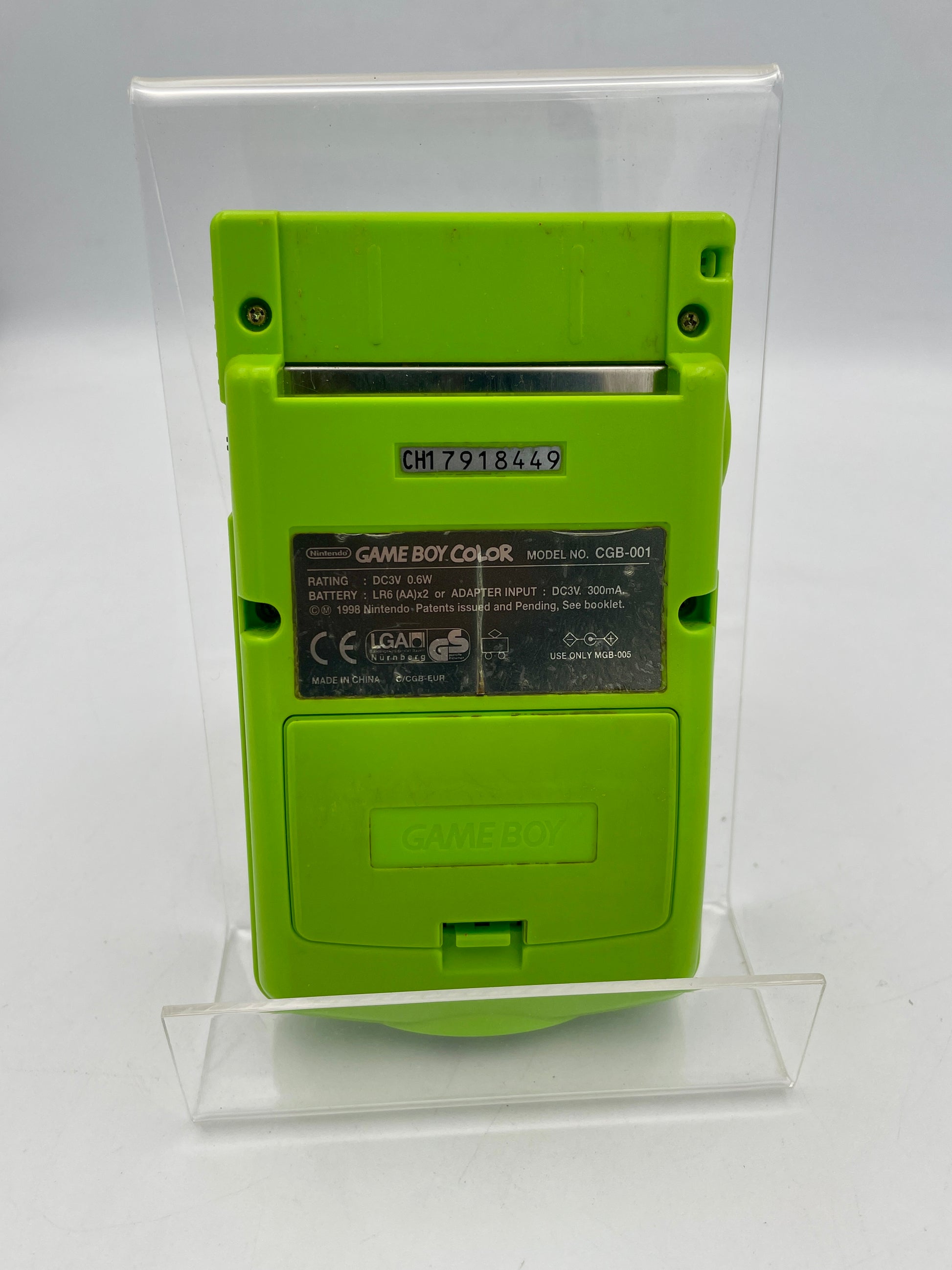 Green Game Boy Color console on a clear stand against a white background
