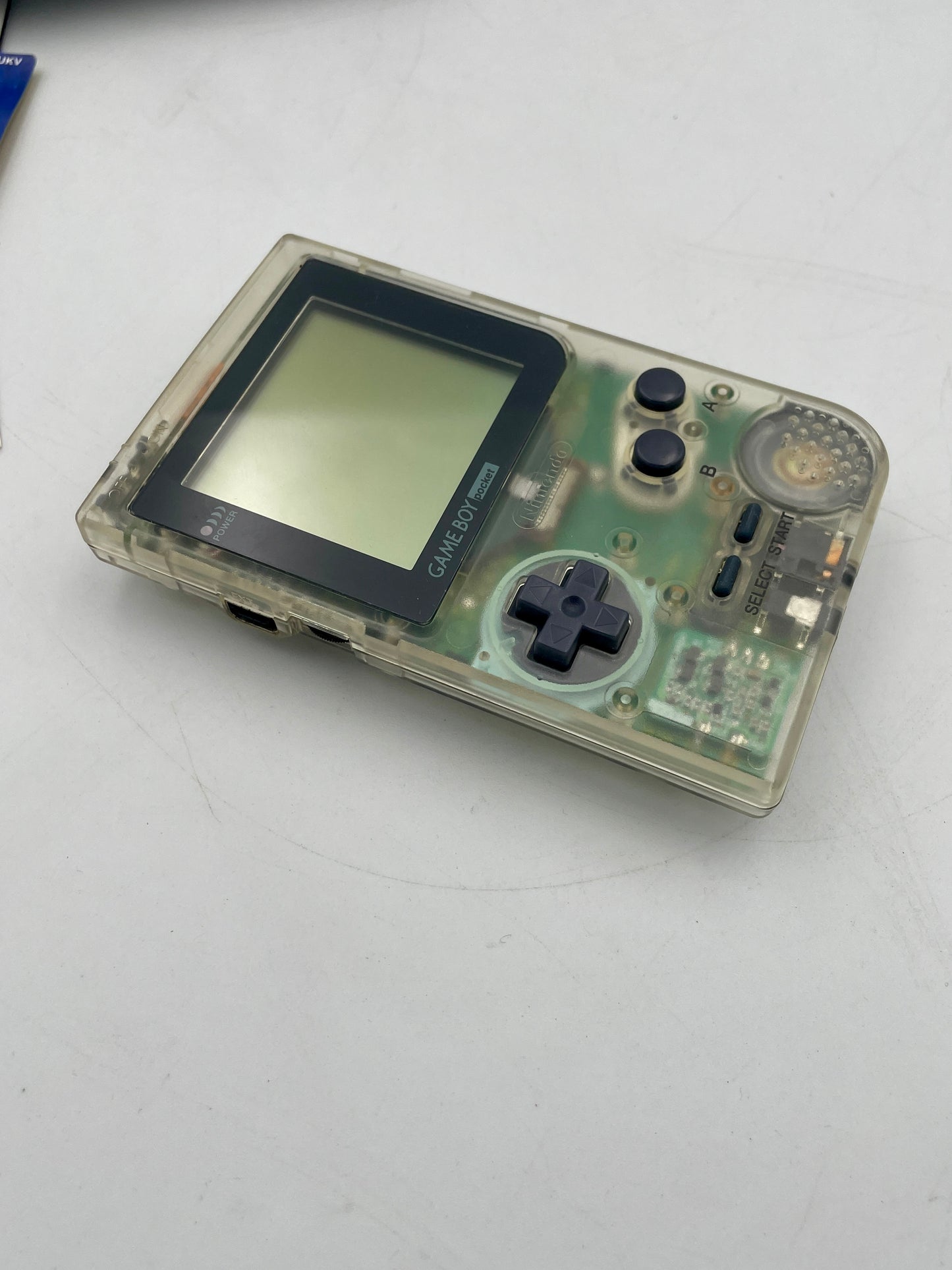 Clear handheld gaming console on a white surface