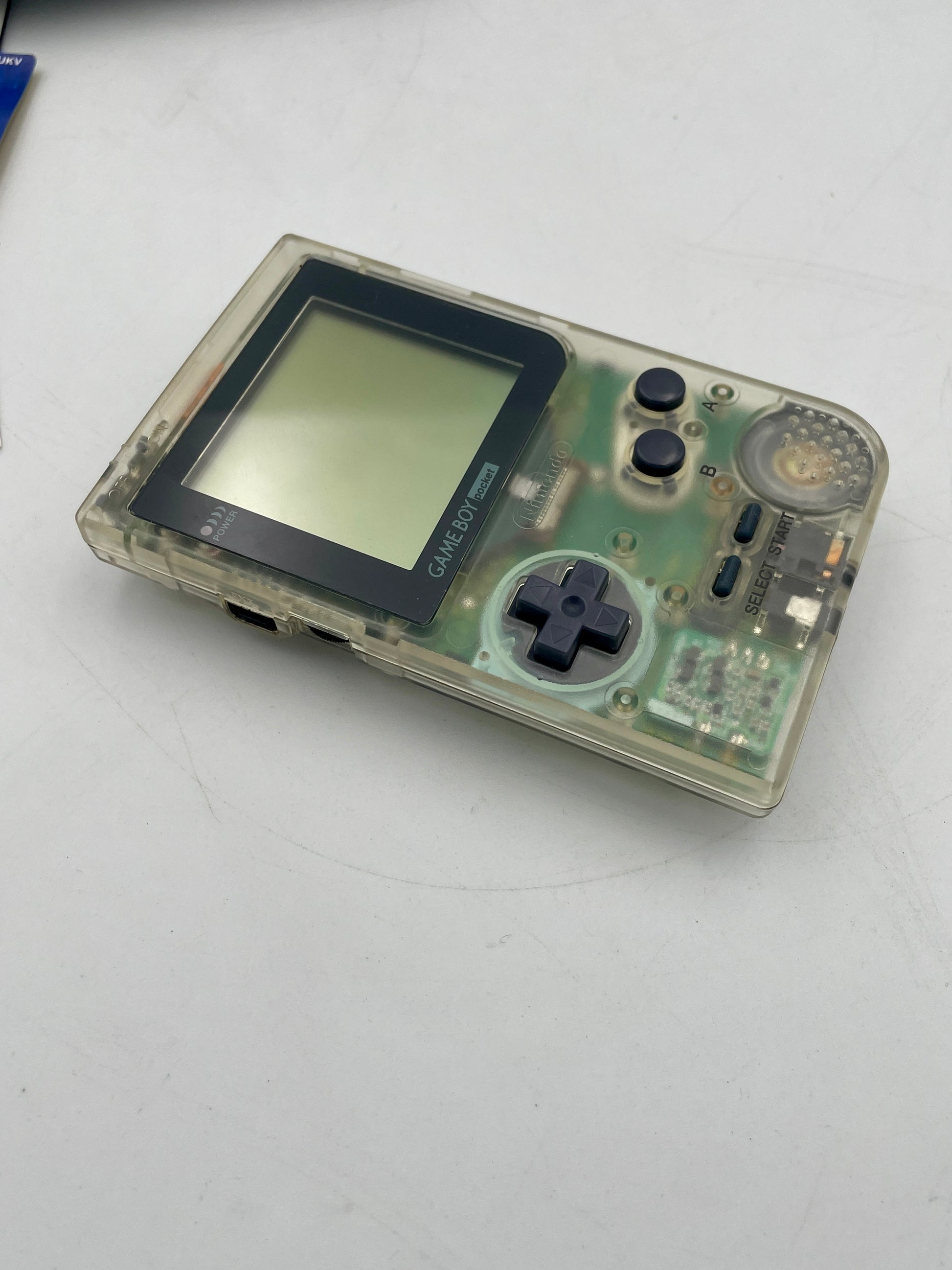 Clear handheld gaming console on a white surface