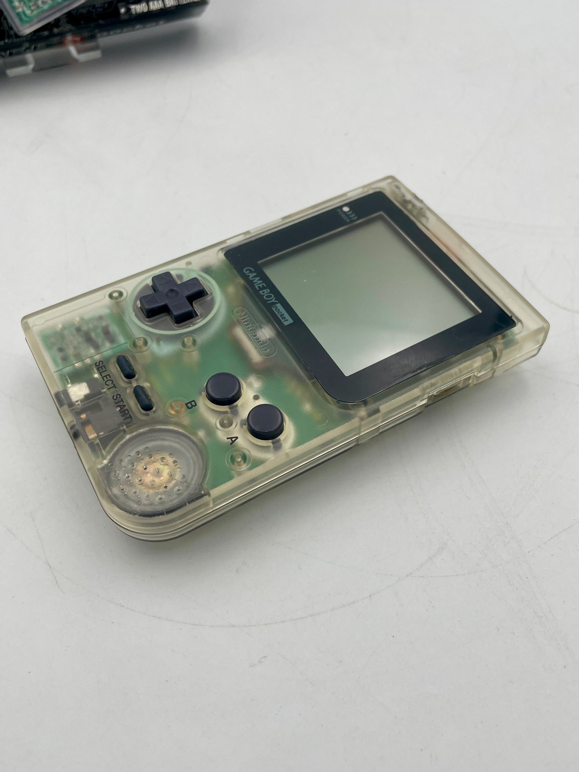 Vintage handheld gaming console with clear casing on a white background