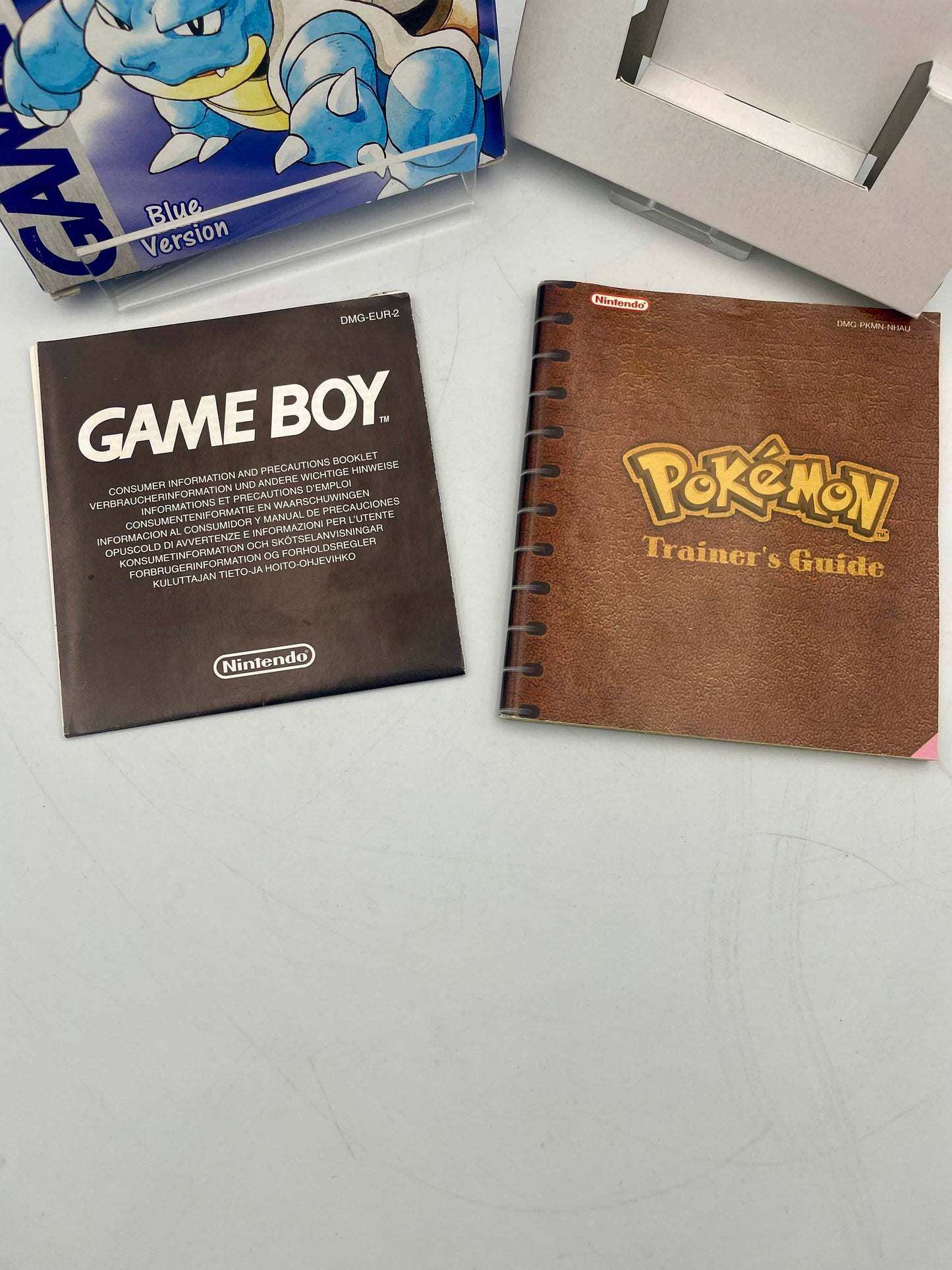 Game Boy manual and Pokémon Trainer's Guide on a white surface