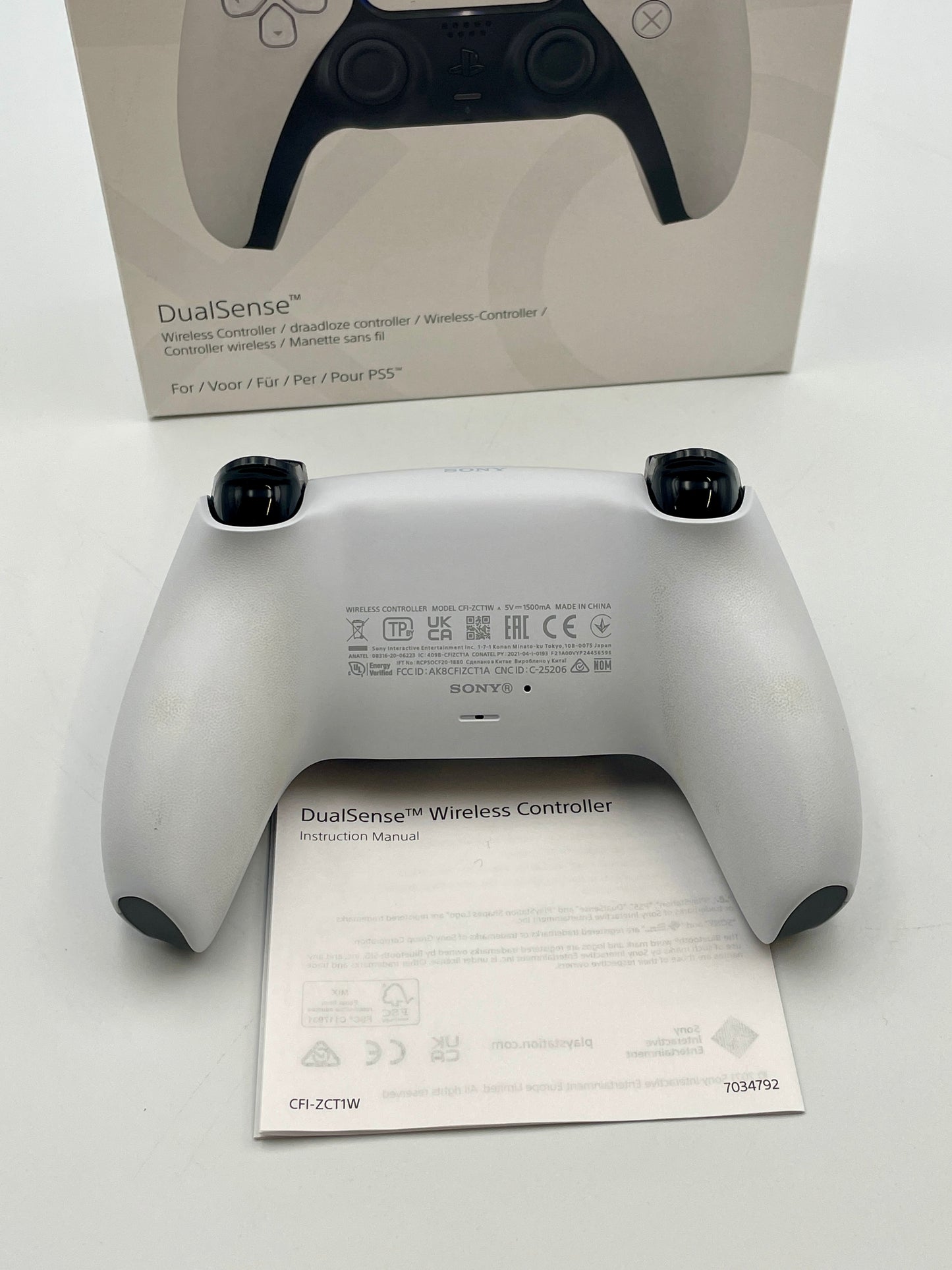 Sony DualSense wireless controller on a white background with packaging in the background
