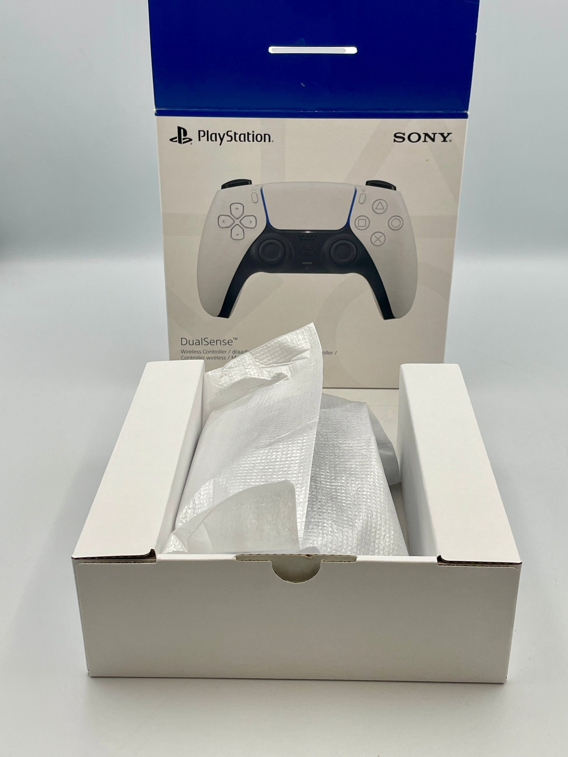 PlayStation DualSense controller packaging with controller inside on a white background
