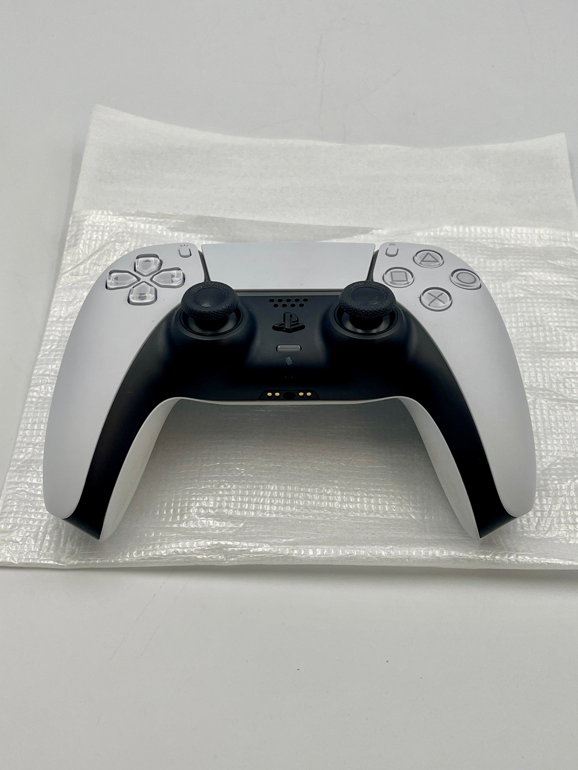 White PS5 Dualsense controller with black accents on a white background