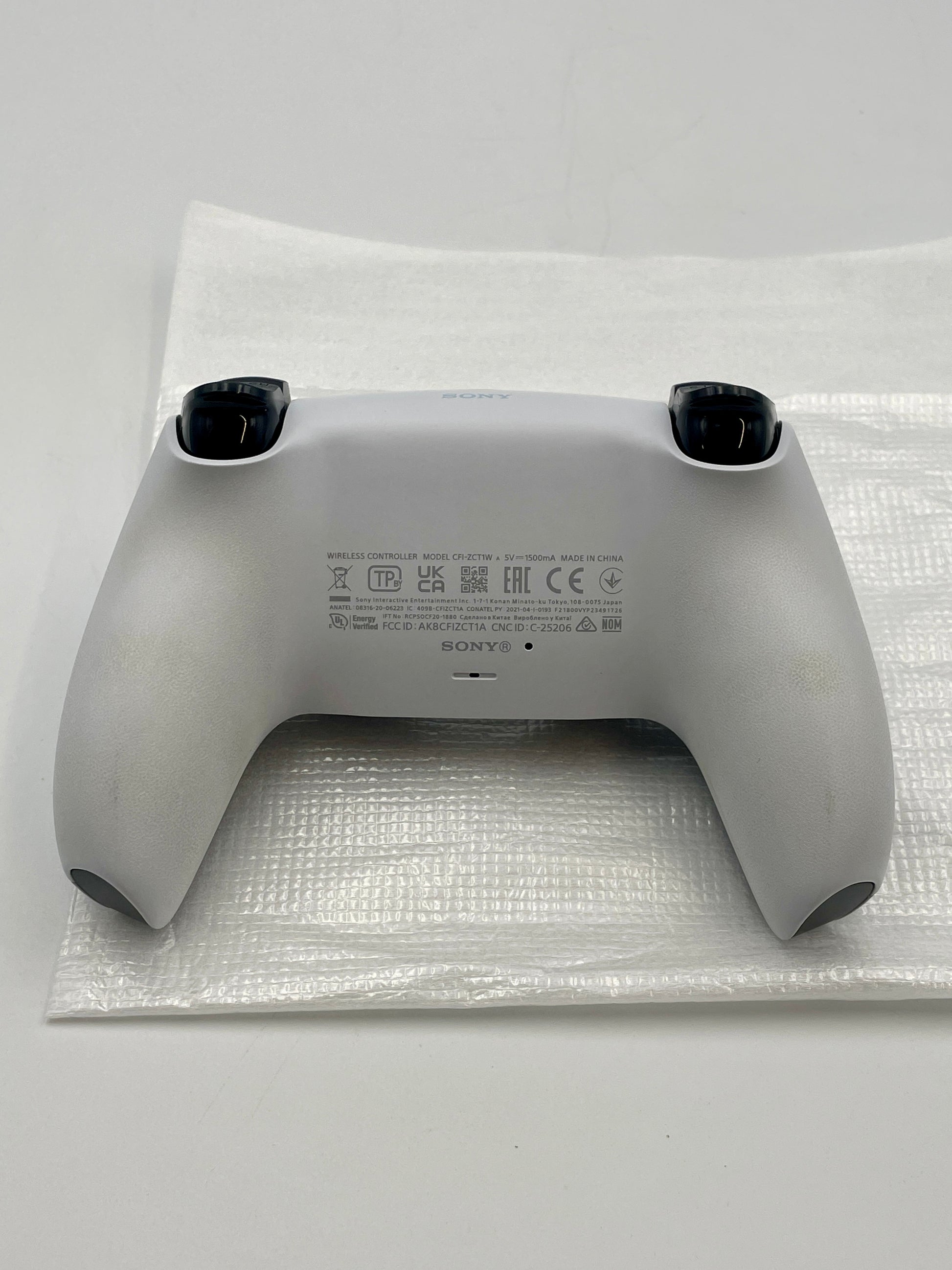 Gray PS5 Dual sense controller  on bubble wrap with Sony branding