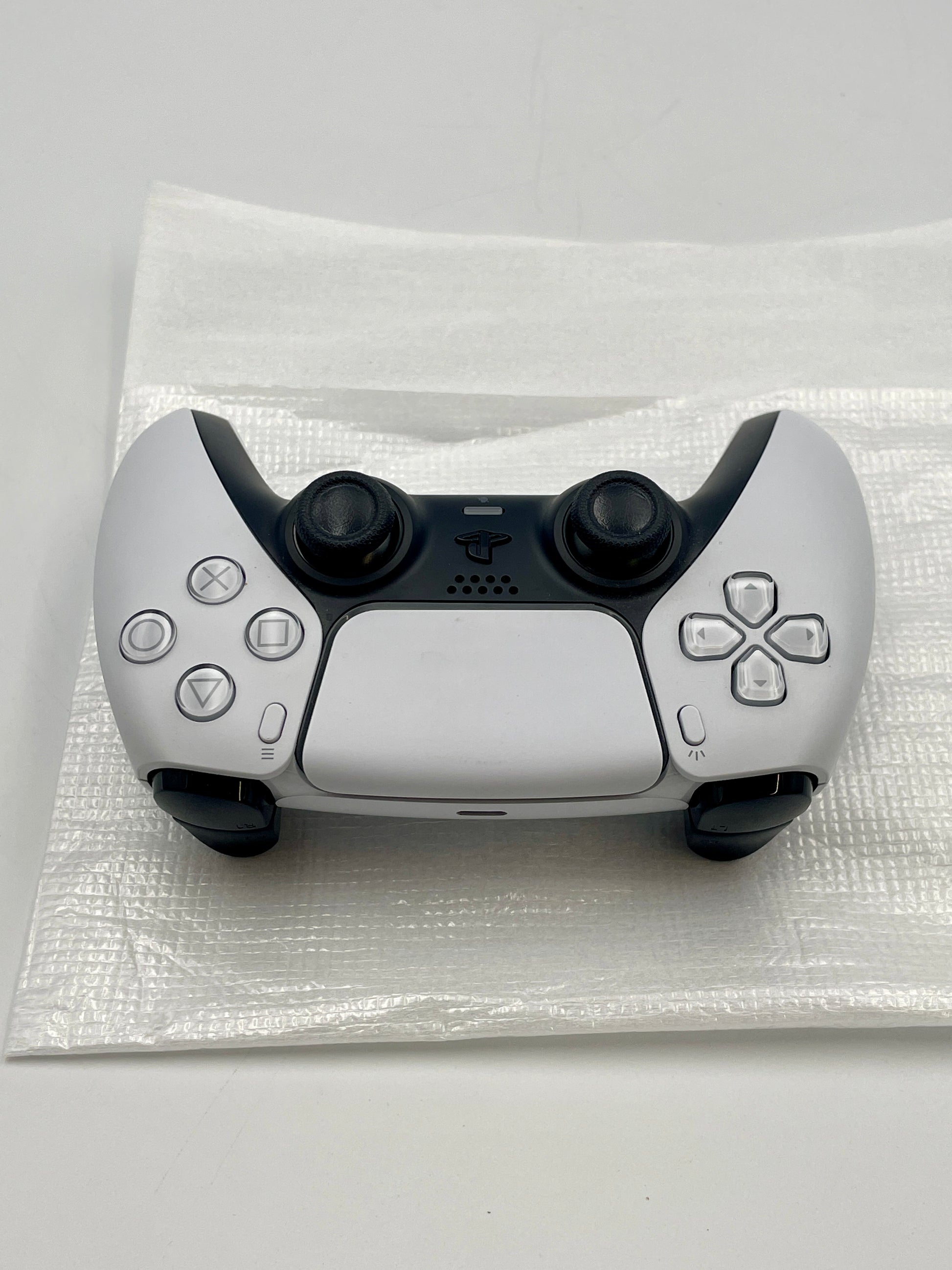 PS5 Dual sense controller on a white surface with a clear protective cover.