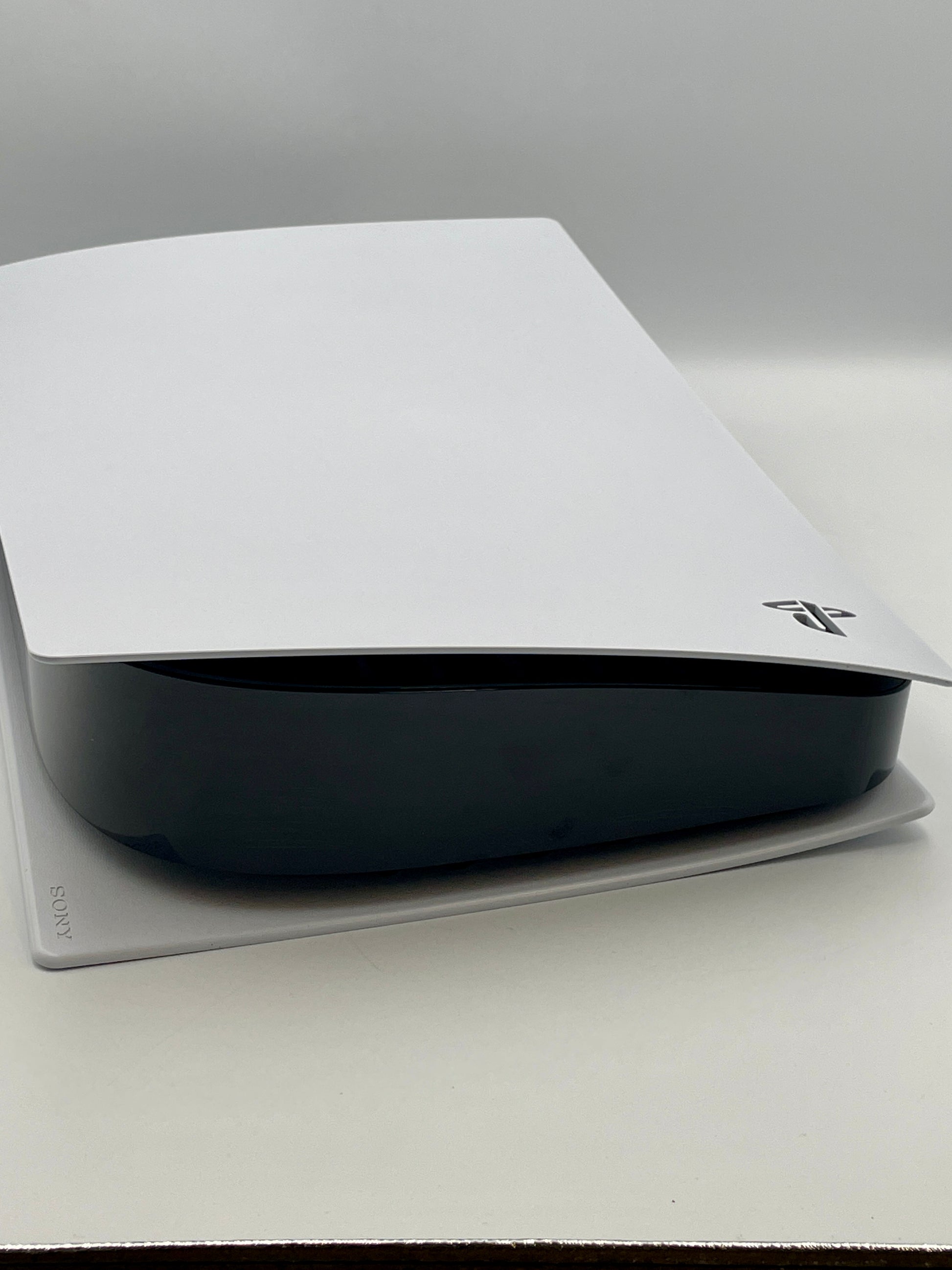 Black electronic device with a white cover on a gray surface