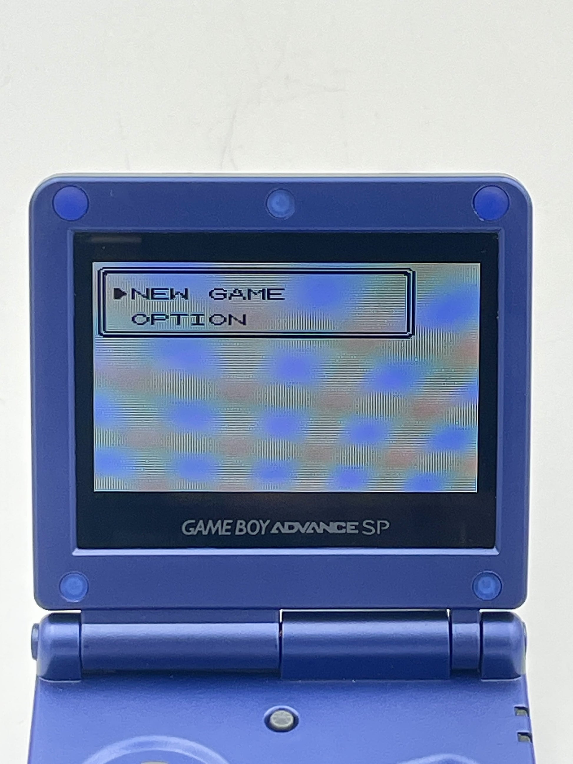Blue Game Boy Advance SP with screen displaying game menu on a white background
