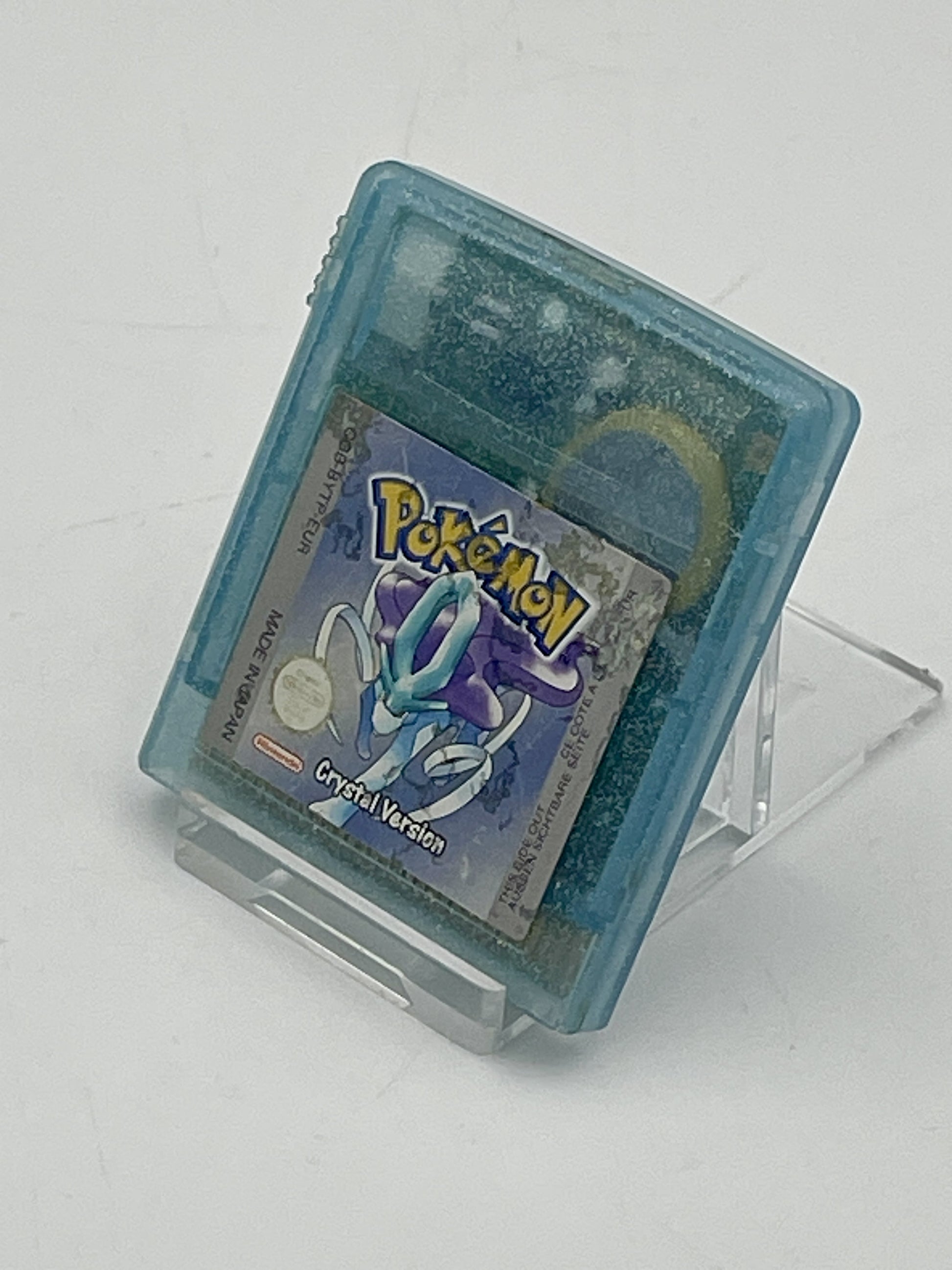 Pokémon Crystal Version game cartridge on a stand with a white background
