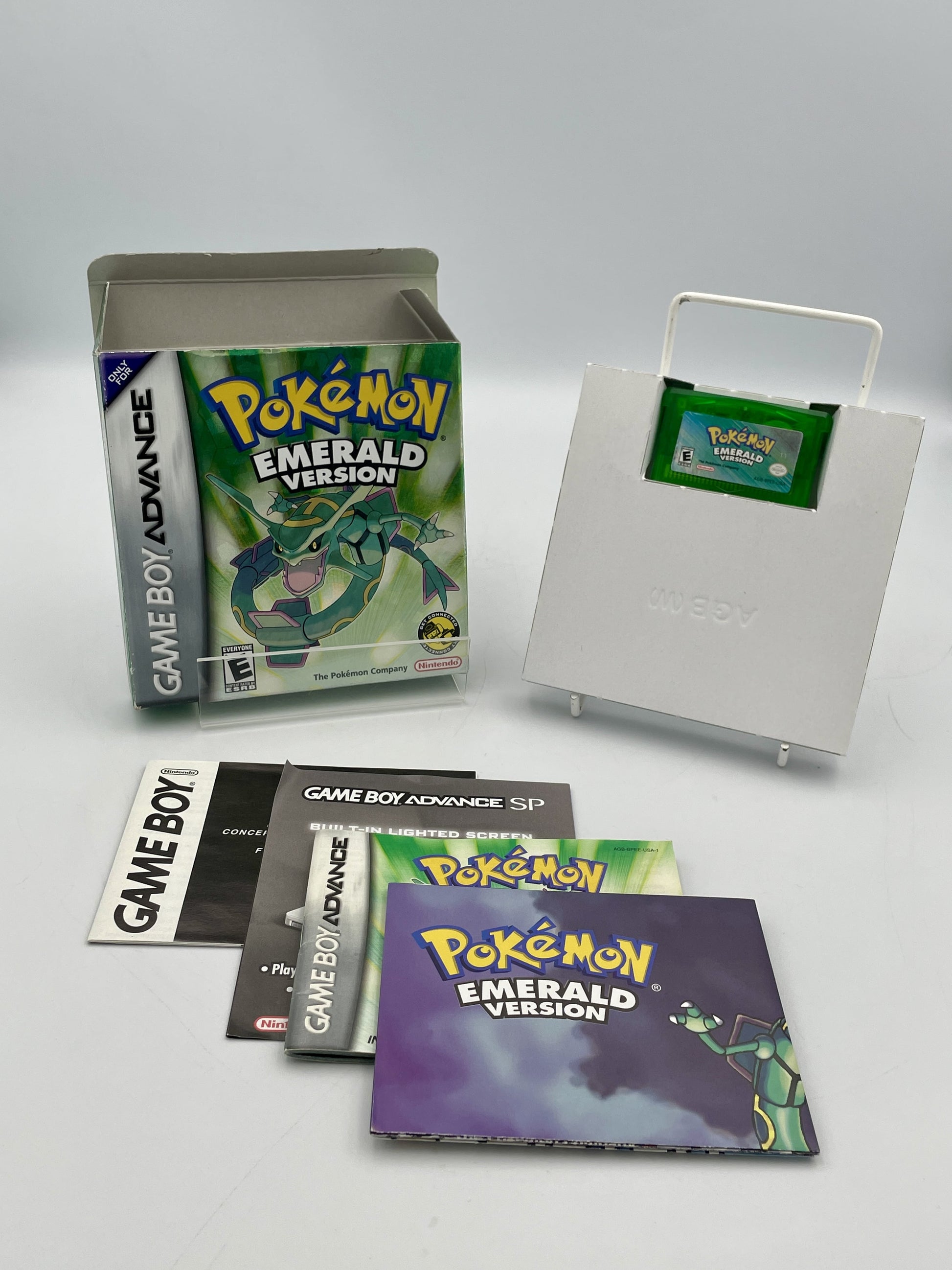 Pokémon Emerald Version Game Boy Advance game case with manuals on a white background