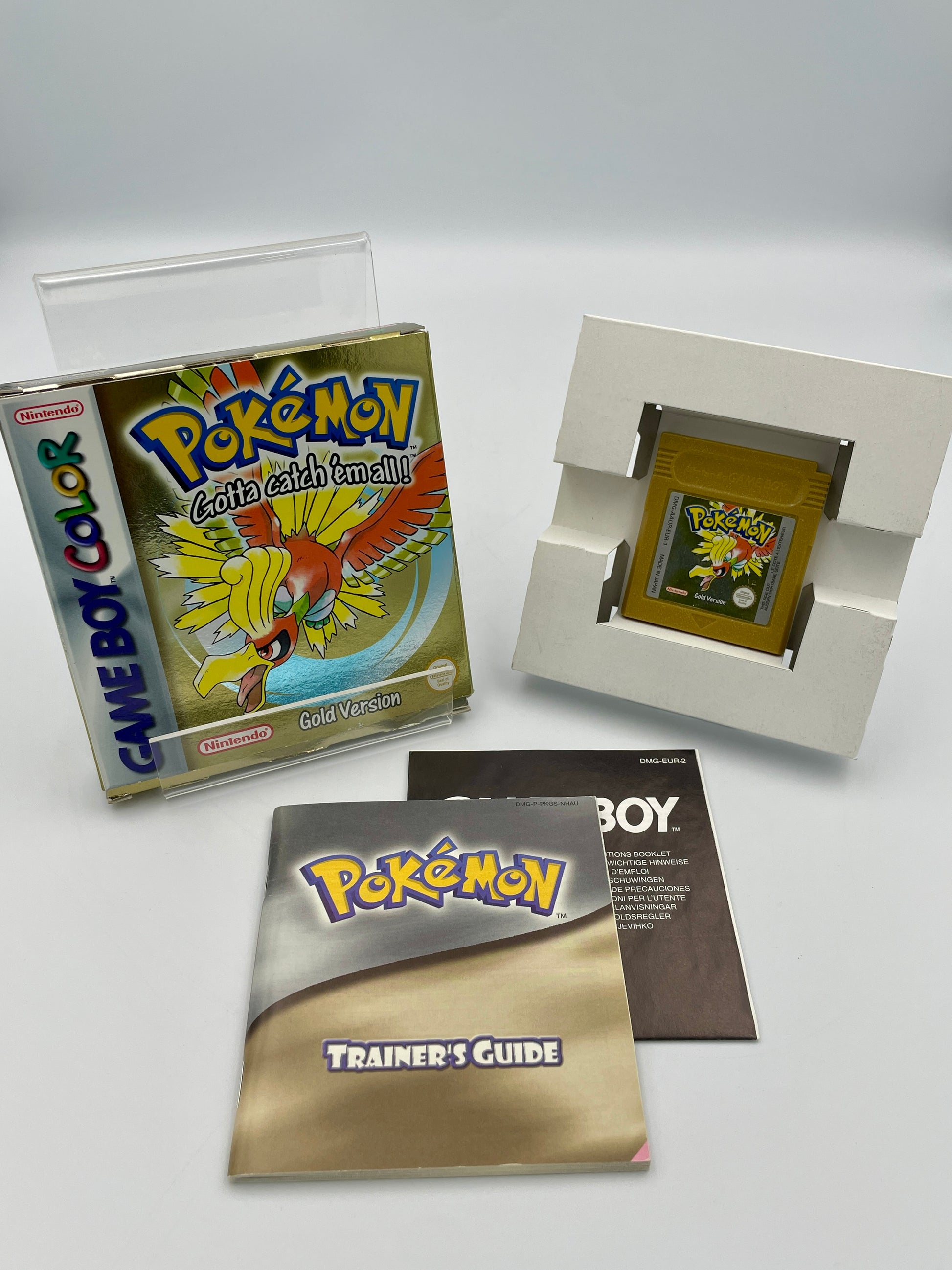 Pokémon Game Boy Color game cartridge with cover and trainer's guide on a white background