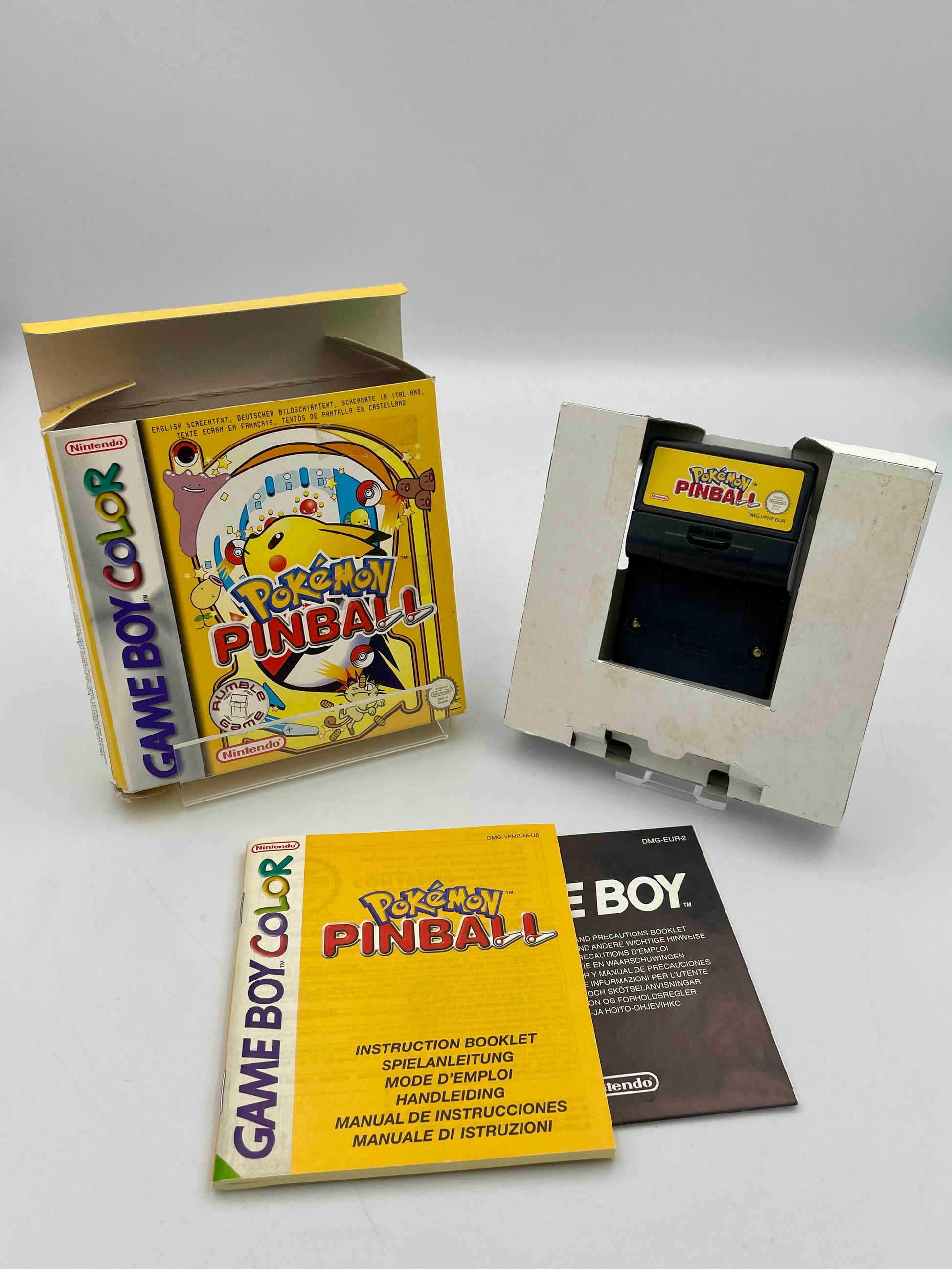 Game Boy Color with 'Pokémon Pinball' cartridge and packaging on a white background
