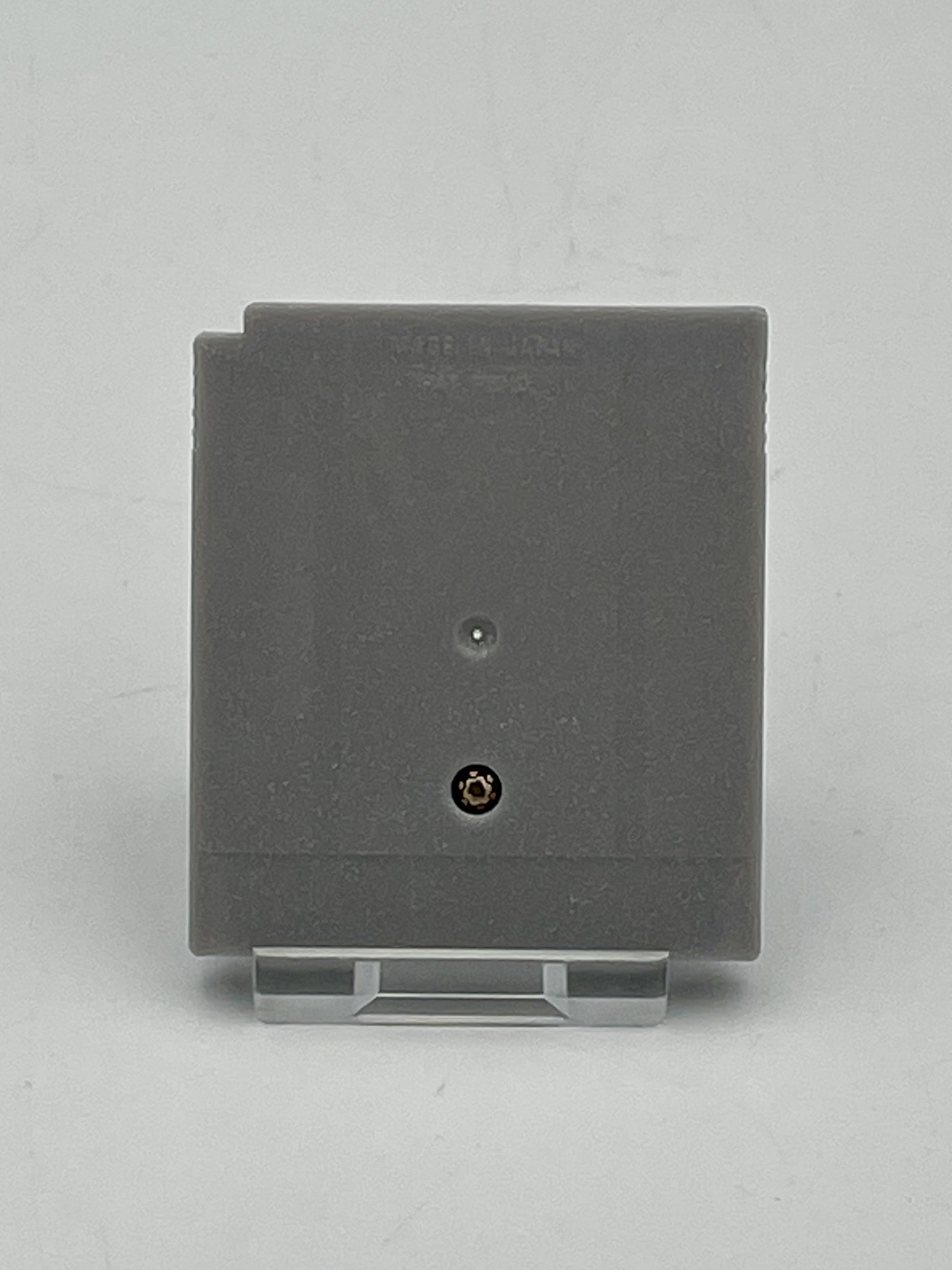 Gray square wall plate with a screw on a light gray background