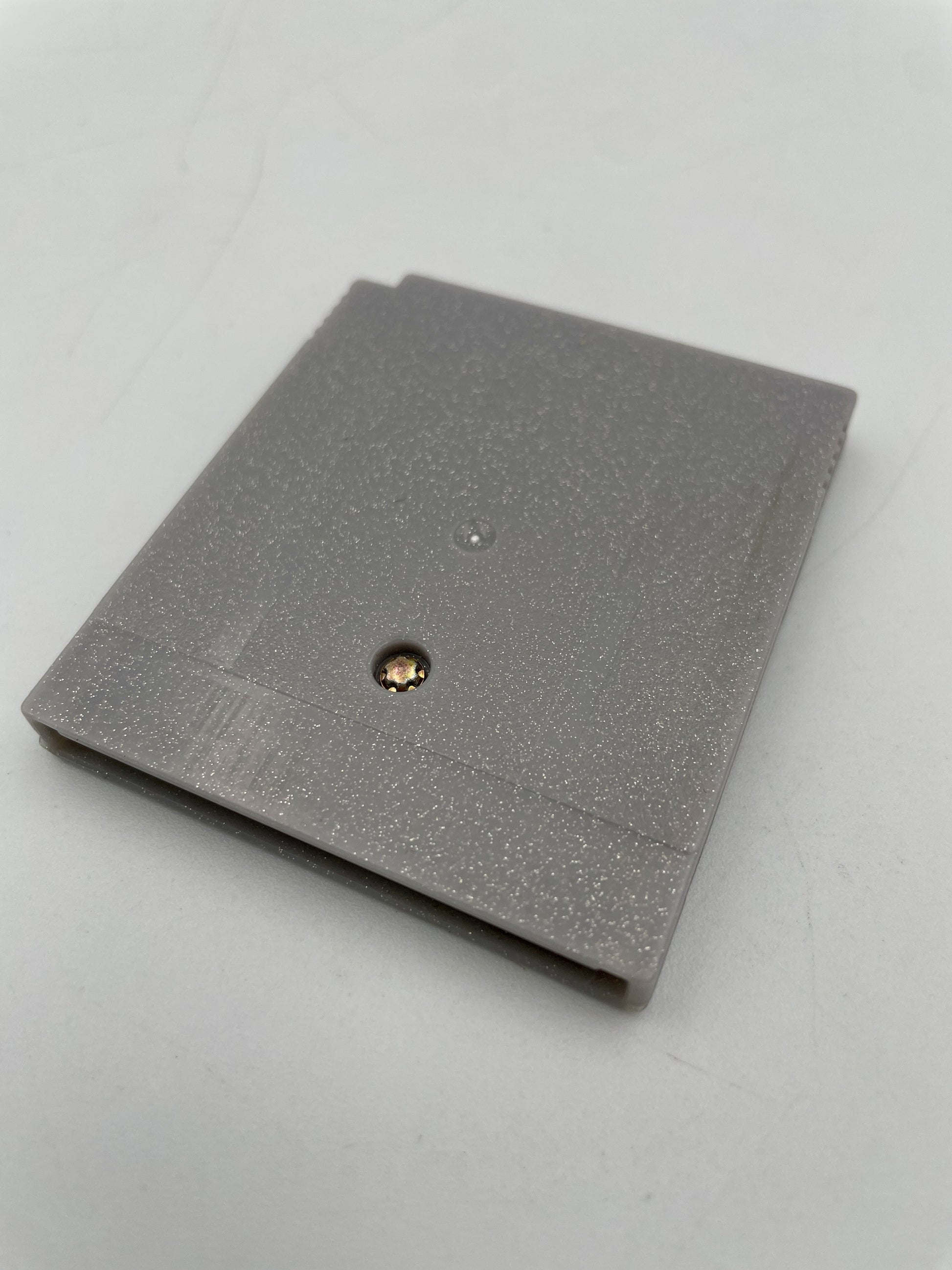 Gray textured notebook with a gold and black button on a light gray background