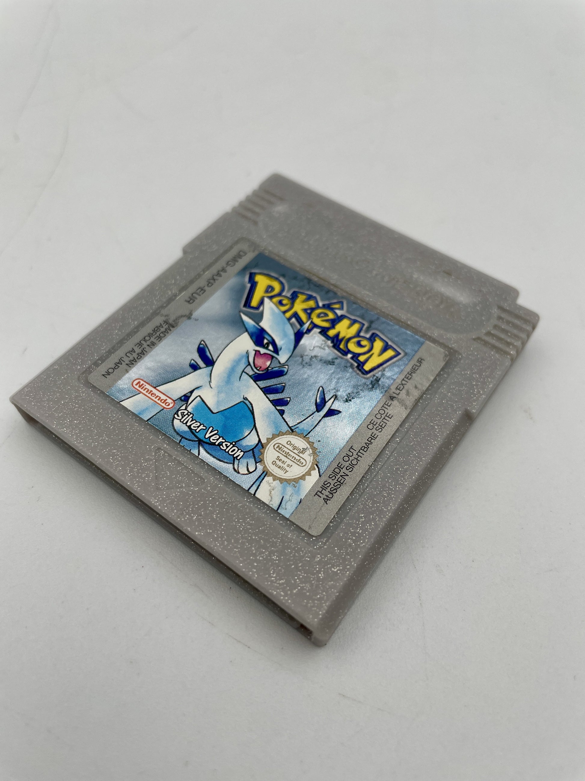 Gray Game Boy Color game cartridge with a Pokémon logo on a white background