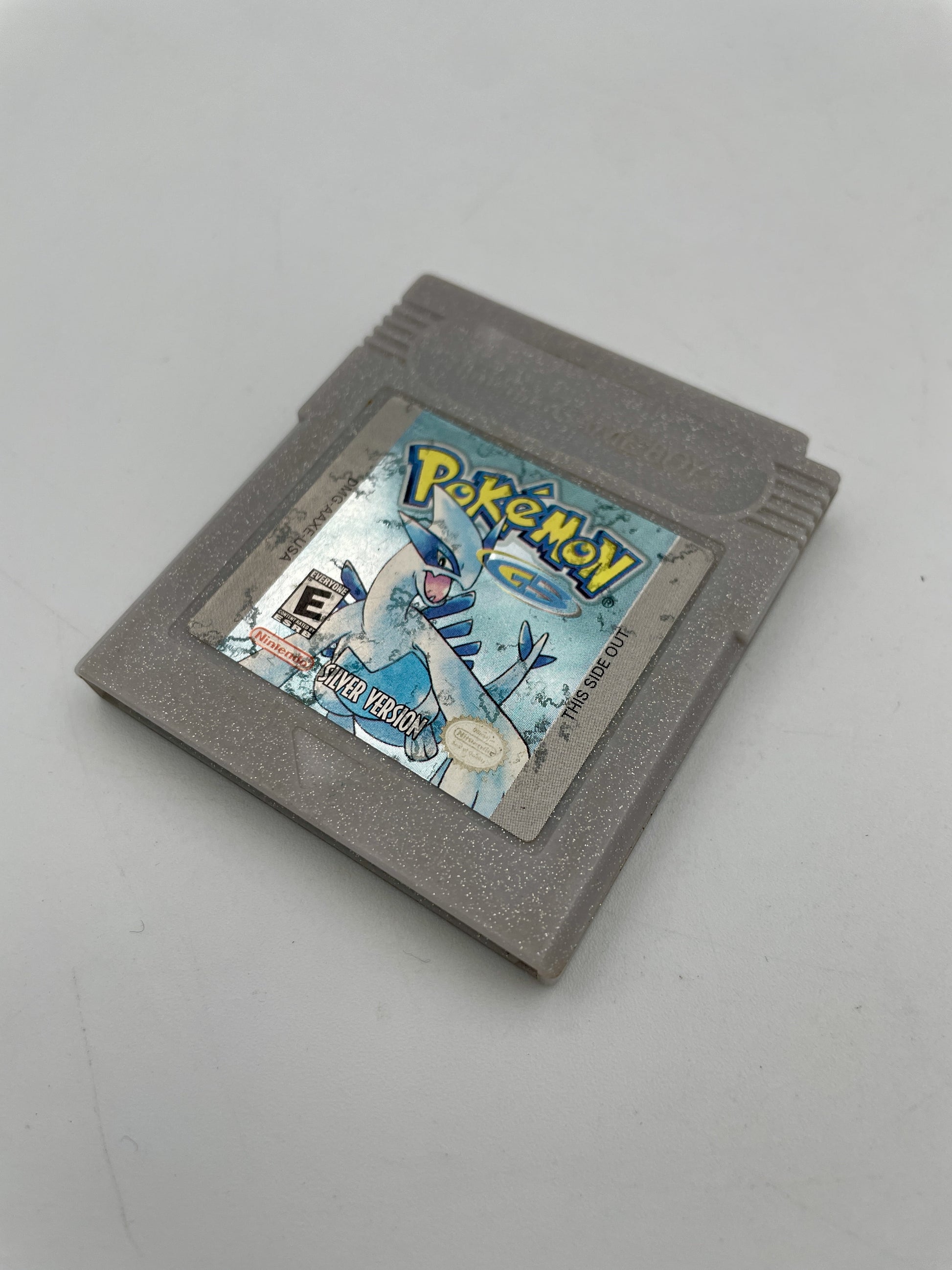 Gray game cartridge with 'Pokémon' branding on a gray background