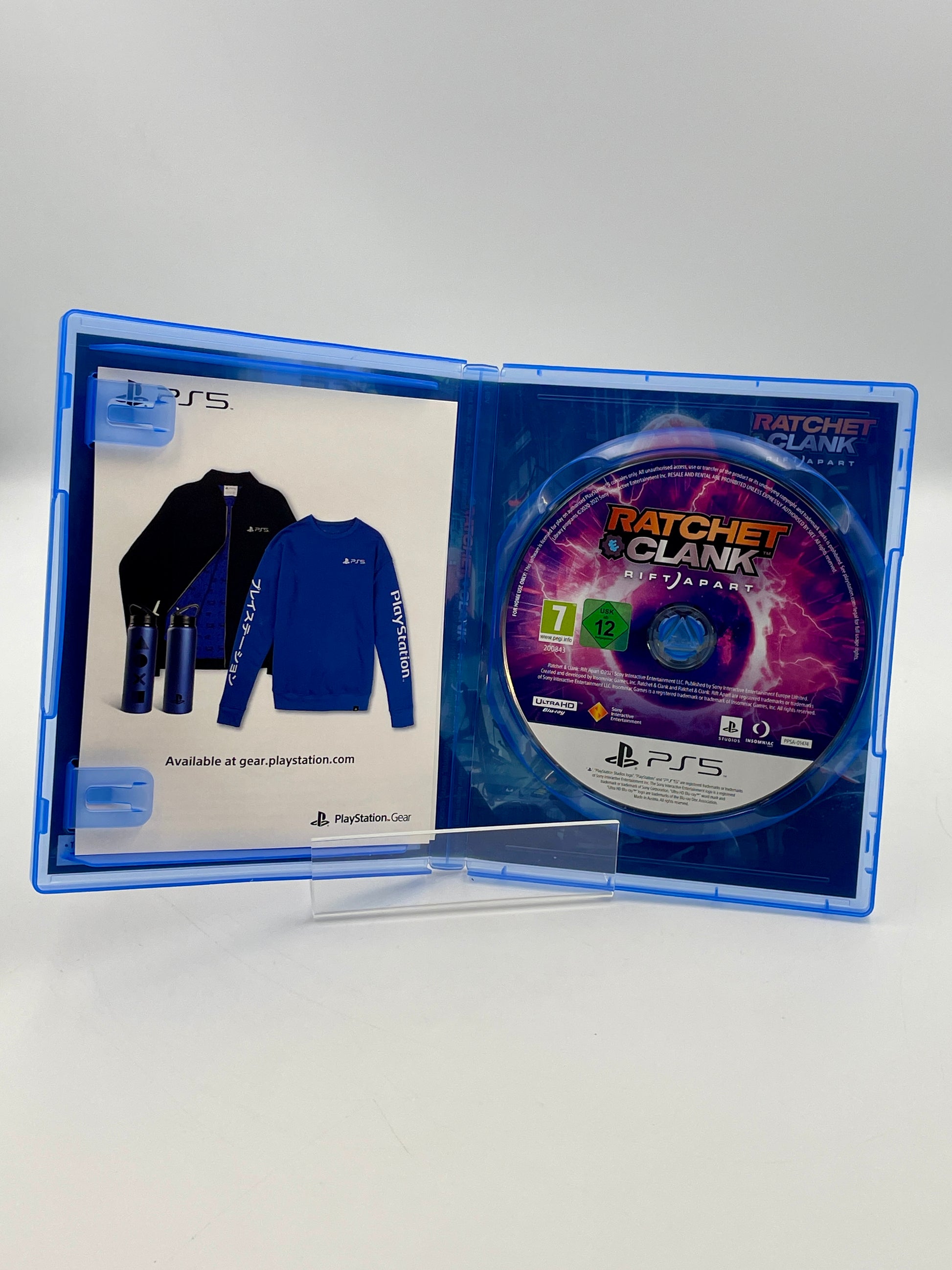 PlayStation 5 game disc in a case with promotional material for 'Ratchet & Clank'.