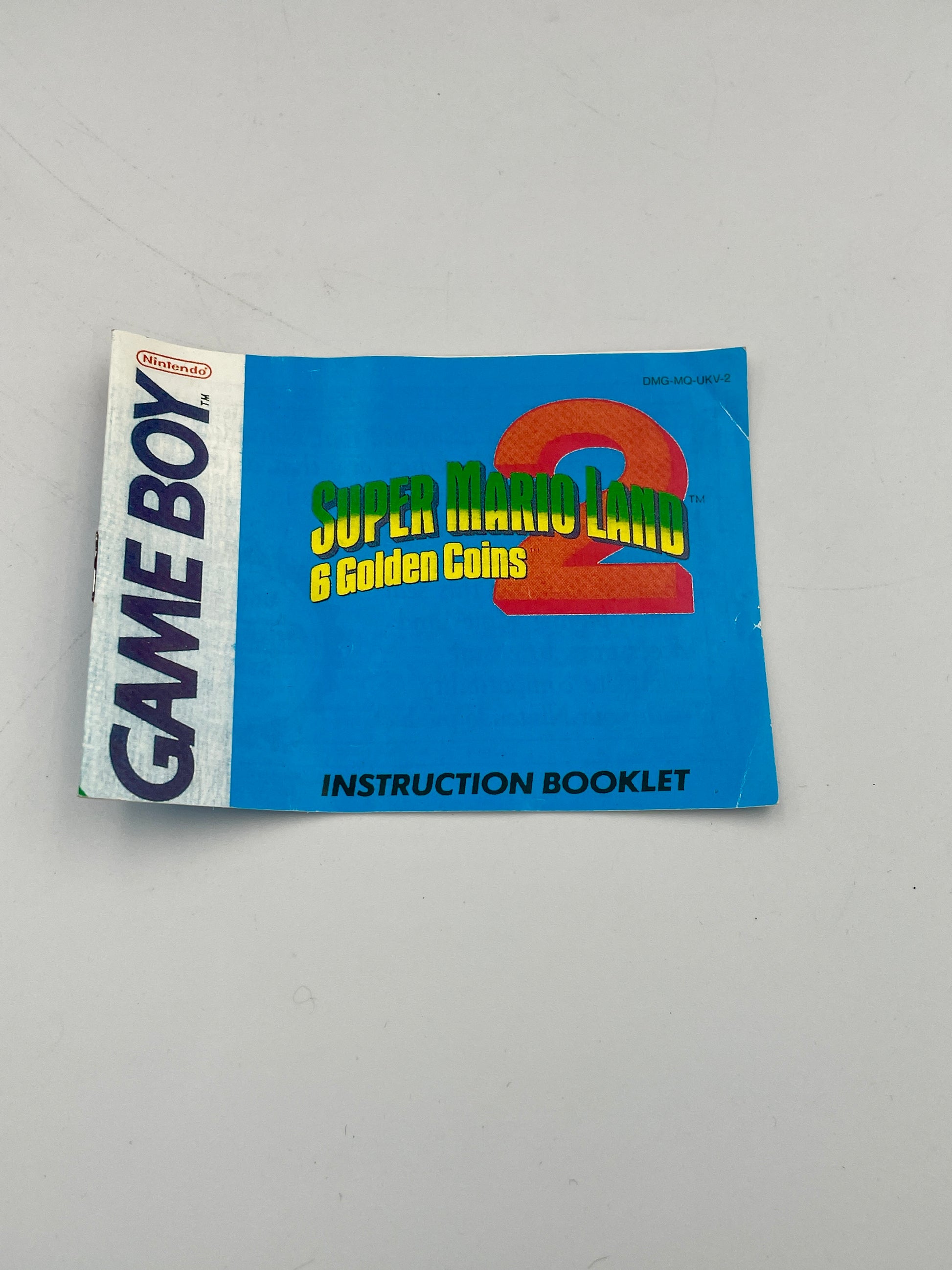 Instruction booklet for Super Mario Land 2: Gold Coins on a Game Boy, on a gray background