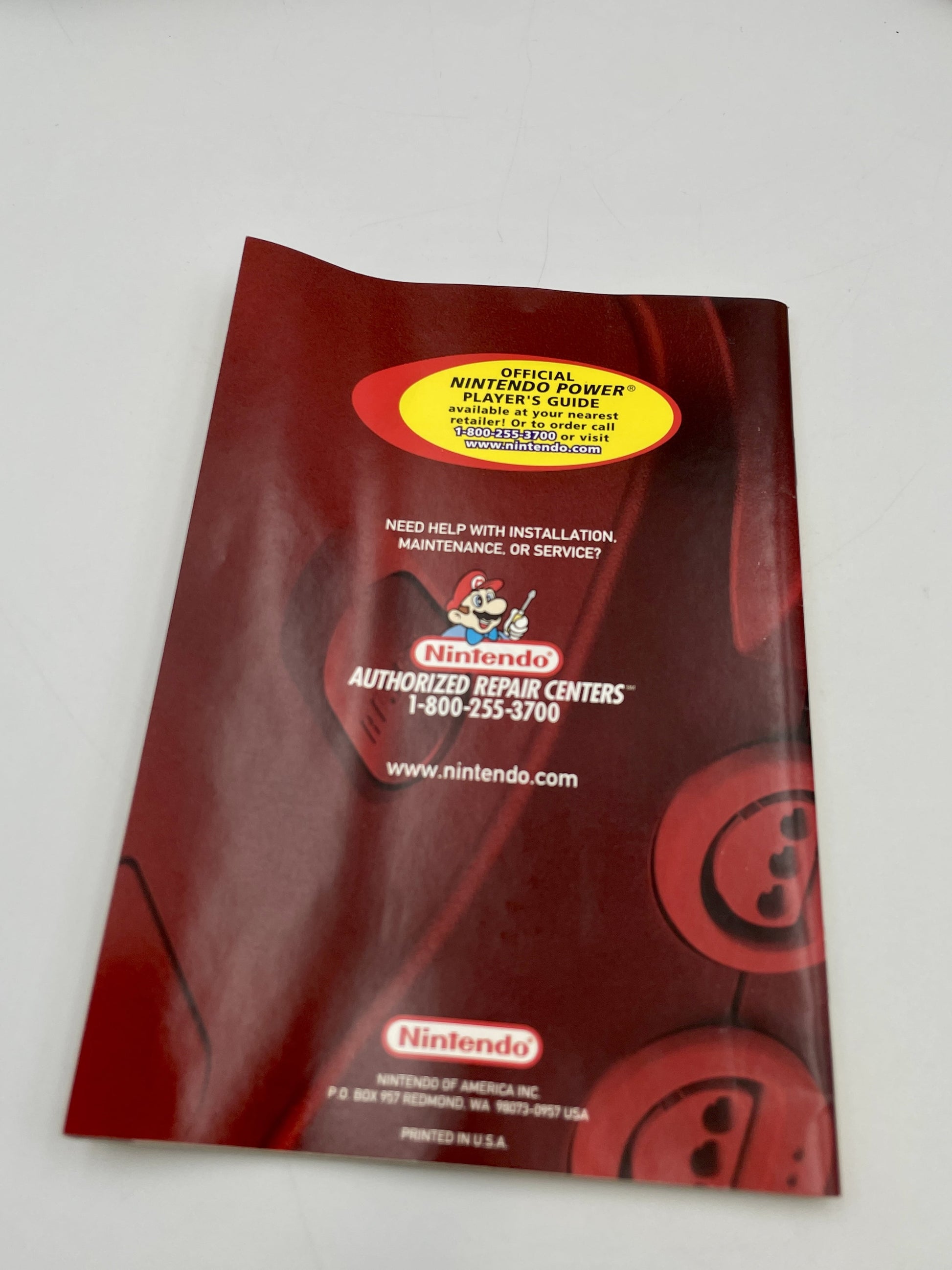 Red Nintendo manual with a yellow label on a white background